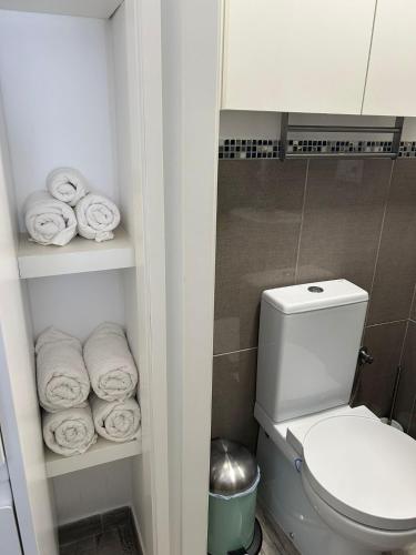 a bathroom with a toilet and a bunch of towels at Loft Barbate in Barbate