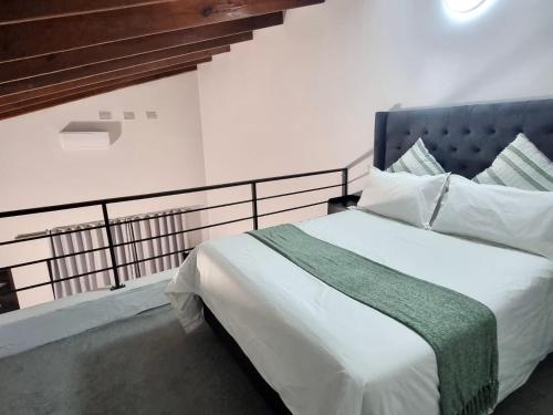 a bedroom with a white bed with a blue headboard at 8 Ladyfish Nook in Richards Bay
