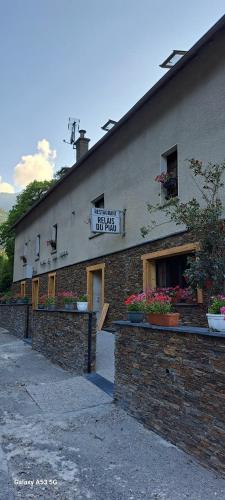 un bâtiment avec une enseigne sur le côté dans l'établissement Hôtel Le Relais de Piau, à Aragnouet