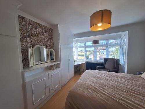 a bedroom with a bed and a mirror and a chair at Elegant Home SW16 Near Station Views Flexible Beds in Streatham Vale