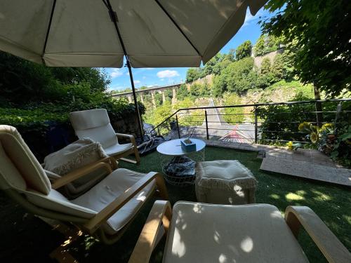 a patio with chairs and an umbrella and a table at Historic Town Luxe and Epic View in Clausen