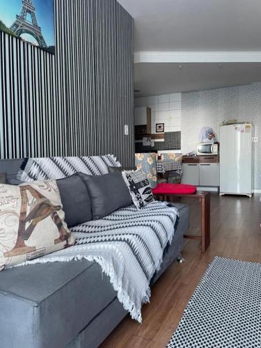 a bedroom with a bed and a kitchen with a refrigerator at FLAT frente Mar Green Diamond in Vila Velha