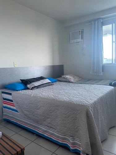 a bedroom with a large bed with blue pillows on it at FLAT frente Mar Green Diamond in Vila Velha
