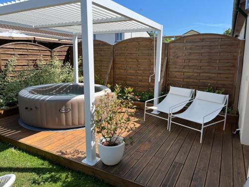 a wooden deck with a hot tub and a pergola at Maison familiale 100m2 in Witry-lès-Reims