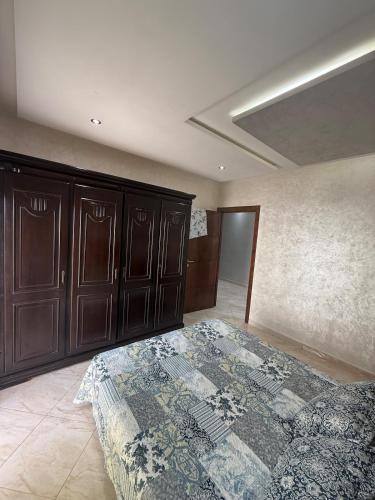 a bedroom with a bed and some wooden cabinets at apartment in complex city center in Oued Laou