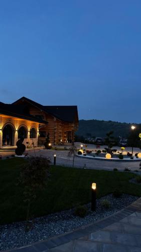 a building at night with a light in the grass at Bucovina Exclusiv in Vama