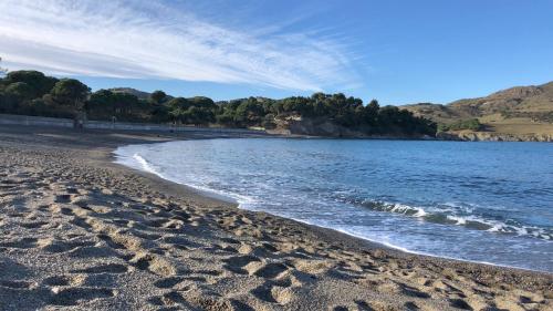 a beach with footprints in the sand and water at Vue Panoramique Exceptionnelle Mer, Montagne et Village l T2 Luxueux in Banyuls-sur-Mer