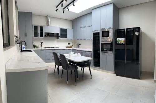 a kitchen with a table and black appliances at فيلا ابها 3 in Abha