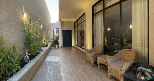 a patio with wicker chairs and a bench in a building at فيلا ابها 3 in Abha