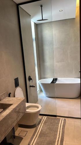 a bathroom with a tub and a toilet and a sink at فيلا ابها 3 in Abha