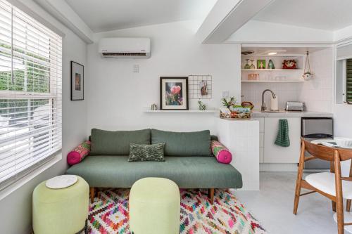 a living room with a green couch and a kitchen at Stagecoach Home Base! Palm Desert Casita with Pool in Palm Desert