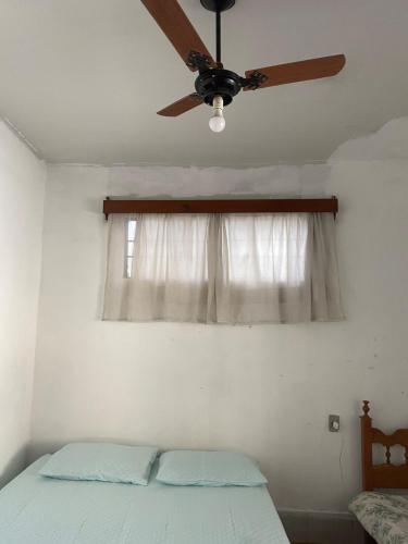 a bedroom with a ceiling fan and a window at Casa Couto Magalhães in Anápolis
