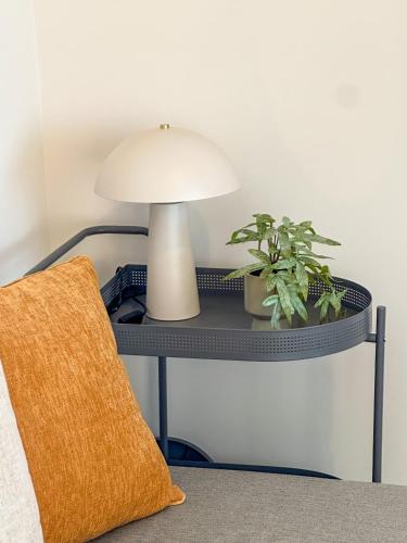 a table with a lamp and a plant on it at Gialos Villas Paleochora in Palaiochóra