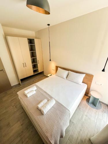 a bedroom with a large white bed and a table at Gialos Villas Paleochora in Palaiochóra