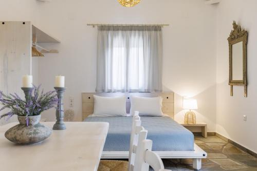 a bedroom with a bed with a table and a window at Bleu & Vert in Skopelos Town