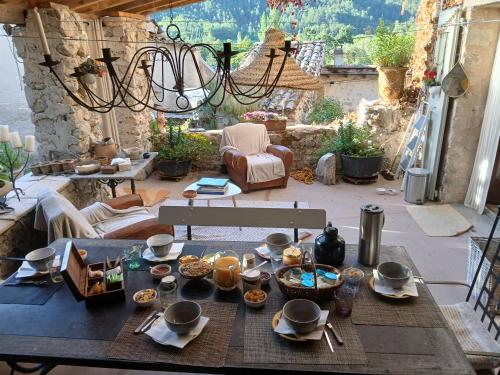 une table avec de la nourriture dessus sur une terrasse dans l'établissement Chambre d'hôtes La Romarine, à Barnave