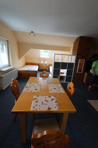 a room with a table and chairs and a bed at Pension Central Ferienwohnungen in Bad Endbach
