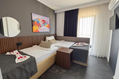 a hotel room with two beds and a mirror at Wolf Of The City Hotel & Spa in Antalya