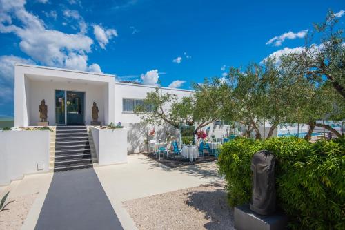 a white building with stairs and chairs in front of it at Monvidal by Bura Hotels - Adults Only in Pula