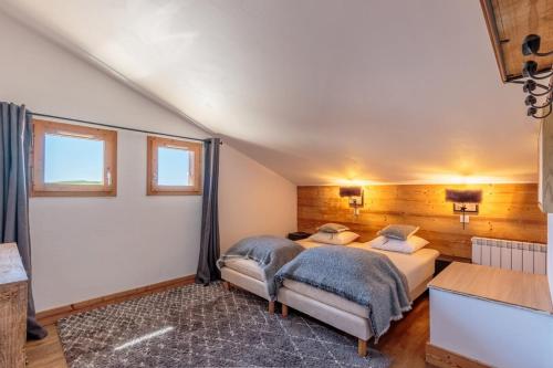 a bedroom with two beds and two windows at Appartement en résidence Belle Plagne Savoie in Belle Plagne