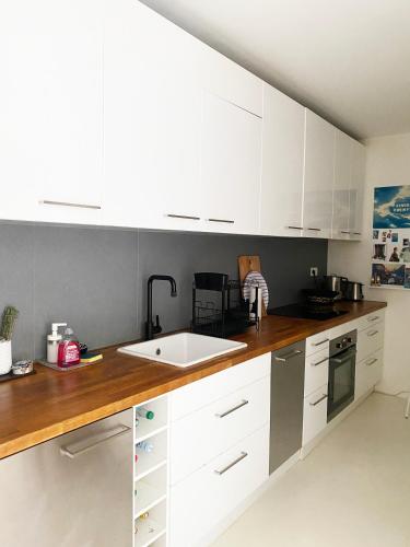 une cuisine avec des armoires blanches et un évier dans l'établissement Havre de paix en plein Paris, à Paris