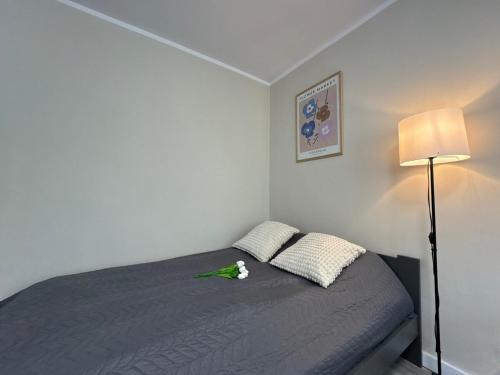 a bedroom with a bed with a green bird on it at Seaside Apartment in Gdańsk