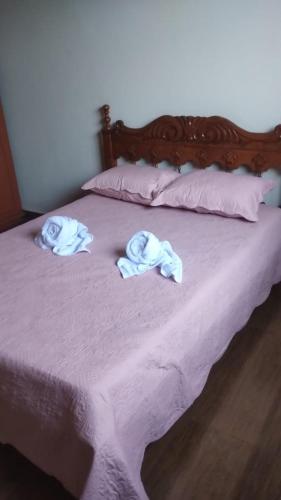 a bed with two towels on top of it at Jardim Secreto in Piumhi