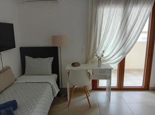 a bedroom with a bed and a desk and a bed and a window at Akrivis studio in Athens