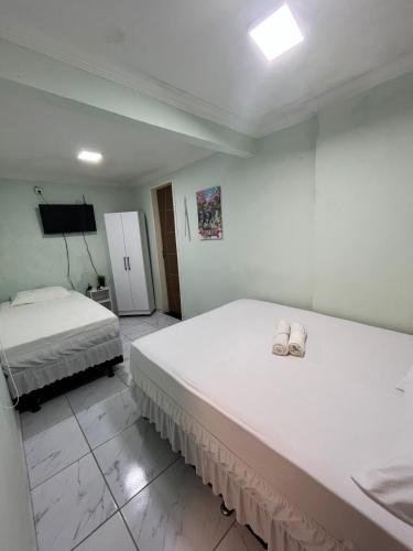 a bedroom with two beds with towels on them at Pousada Alameda Boa Vista in Recife
