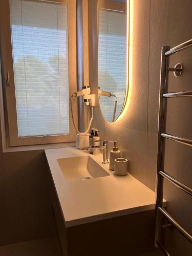 a bathroom with a sink and a mirror at MiMi Palanga - Self Check-in in Palanga