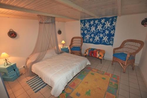 - une chambre avec un lit, deux chaises et un tapis dans l'établissement Villa CAPBRETON 5 personnes, à Capbreton