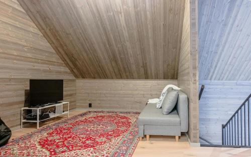 a living room with a chair and a television at Modern villa close to sea & nature! in Örnsköldsvik