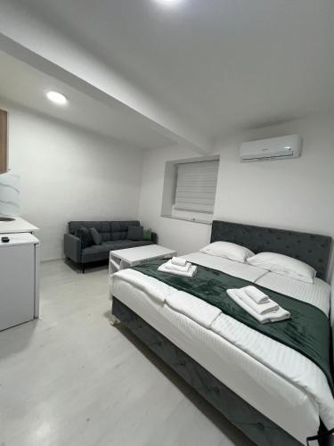 a bedroom with a large bed and a couch at Central Park Residence in Sarajevo