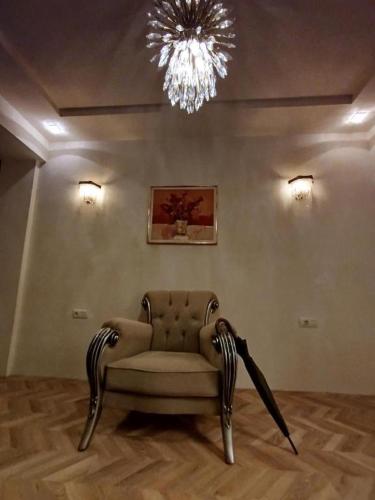 a living room with a chair and a chandelier at Baku Artpatena Lake view in Baku