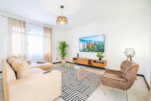 a living room with a couch and two chairs at Lighthouse view- POOL VILLA in Porto Moniz