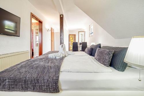 a bedroom with a large white bed with blue pillows at Haus Windhook in Dierhagen