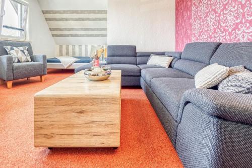 a living room with a blue couch and a wooden coffee table at Haus Windhook in Dierhagen