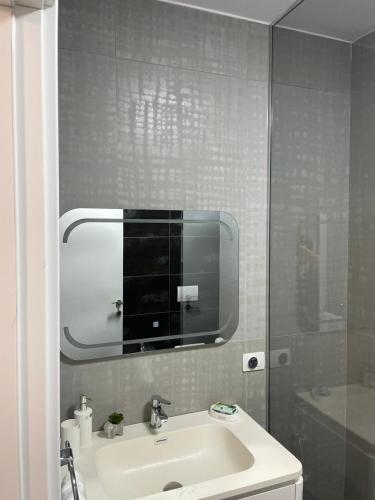 a bathroom with a sink and a mirror at Dolce Mare Luxury Apartment in Shëngjin