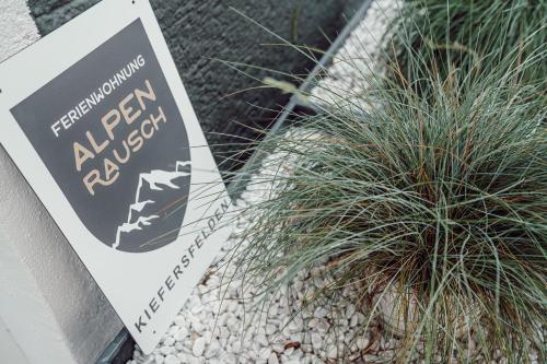 a sign sitting next to a potted plant at Alpenrausch 3 in Kiefersfelden