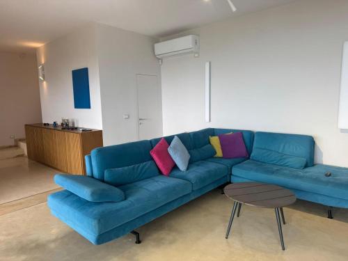 a blue couch with colorful pillows in a living room at Villa Horizon Dhermi in Dhërmi