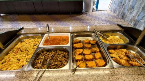 a buffet filled with different types of food in trays at Grand Beach Hotel Thassos in Limenaria