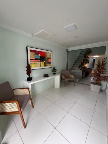 a living room with a table and chairs and stairs at Pousada Alameda Boa Vista in Recife
