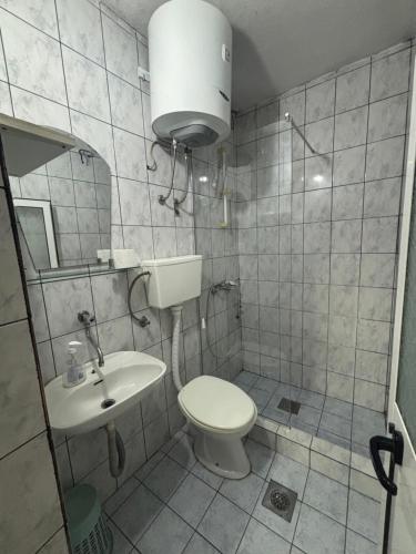un baño con inodoro y lavabo en Centrum Apartman & Rooms, en Ulcinj