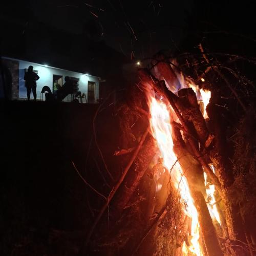 a fire burns in front of a house at night at DORMITORIOS - BAÑO y TV in Guarne