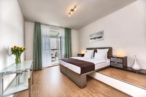 プラハにあるOstrovni 7 Apartmentsのベッドルーム1室(ベッド1台、ガラス張りのテーブル付)