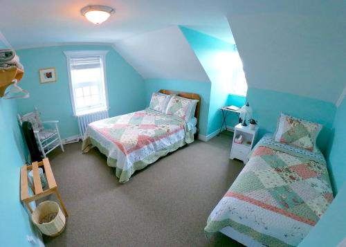 a bedroom with two beds and blue walls at Chez Caro et Sylvain in Rimouski