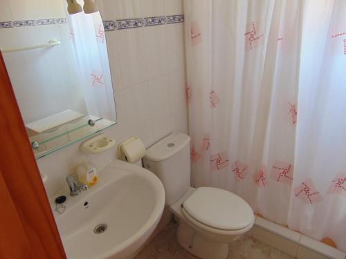 La salle de bains est pourvue de toilettes blanches et d'un lavabo. dans l'établissement Fiesta 165, à Mazarrón