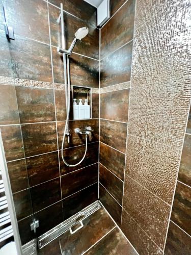 a bathroom with a shower with brown tiles at 4 mins walk Thalwil Station, Free Parking, Historical in Thalwil