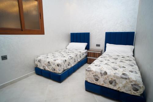two beds in a room with blue frames at Luxury apartment in Tangier 2 in Tangier