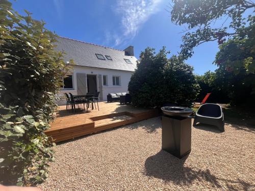 une arrière-cour avec une terrasse en bois et une maison dans l'établissement La maison de Marie, à Plovan
